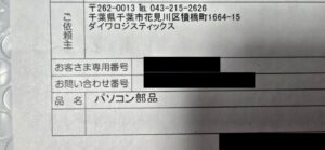 無地ダンボールに貼られたNLSの送り状。品名欄はパソコン部品、依頼主はダイワロジスティックス