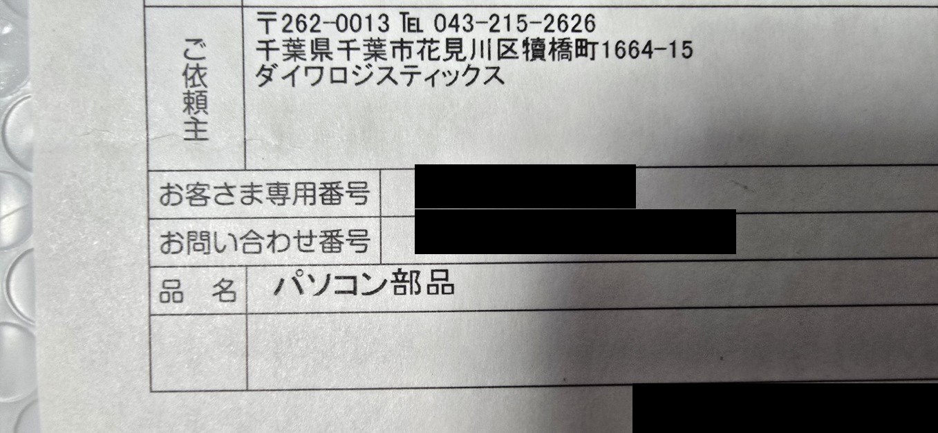 無地ダンボールに貼られたNLSの送り状。品名欄はパソコン部品、依頼主はダイワロジスティックス